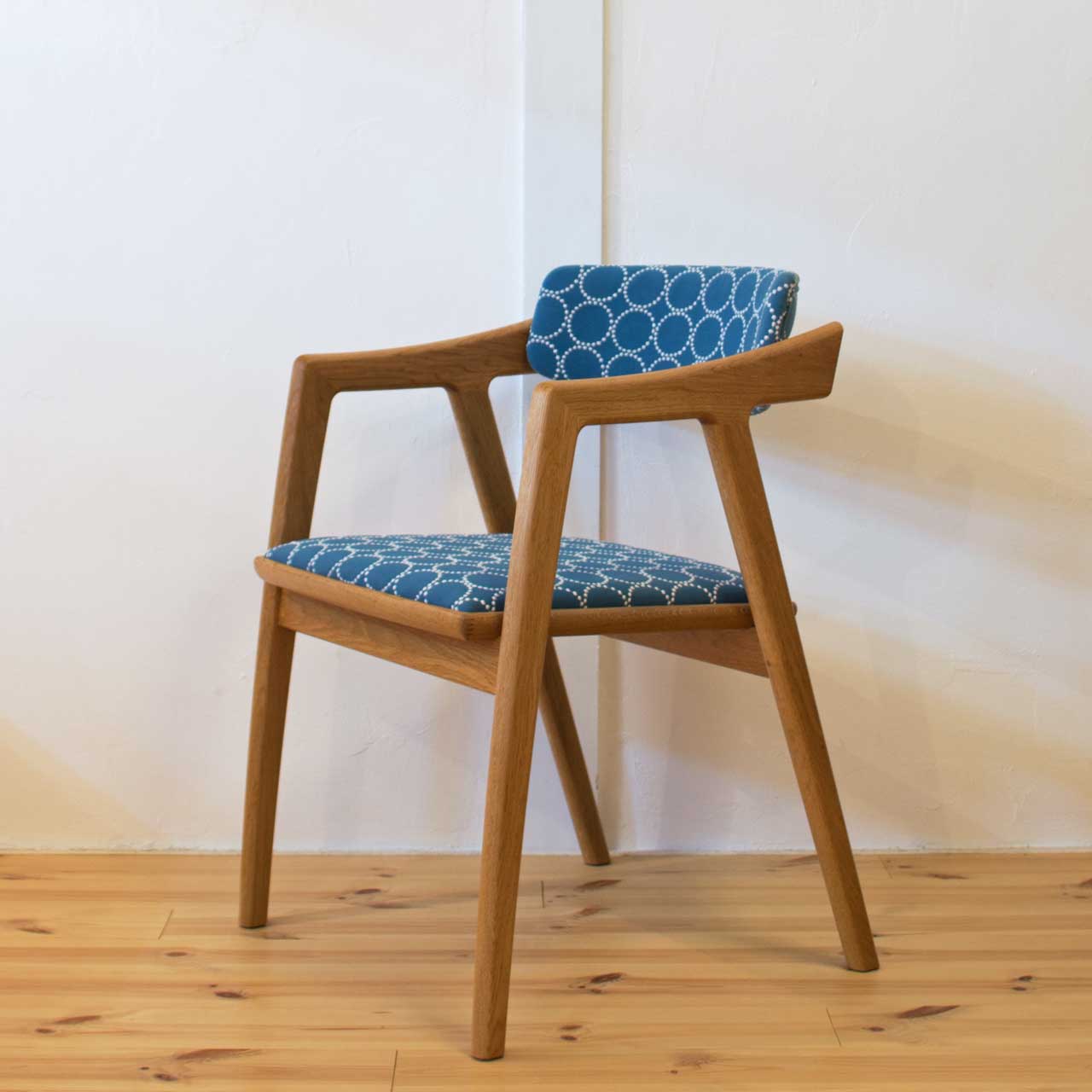 ミナペルホネンのタンバリン生地を使用したGENチェア。ISU-WORKS（イスワークス）の木製椅子の全体を斜めから撮影