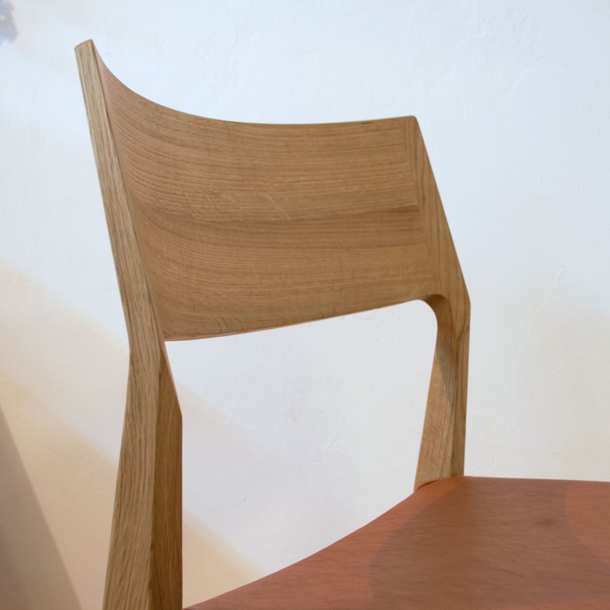 斜め前から見た日進木工 DCC-096 チェア（オーク材）の背もたれ