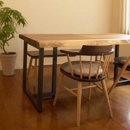 高山ウッドワークスのキャプテンチェアをダイニングテーブルと合わせた使用例。アームが、天板下に無理なく収まる様子